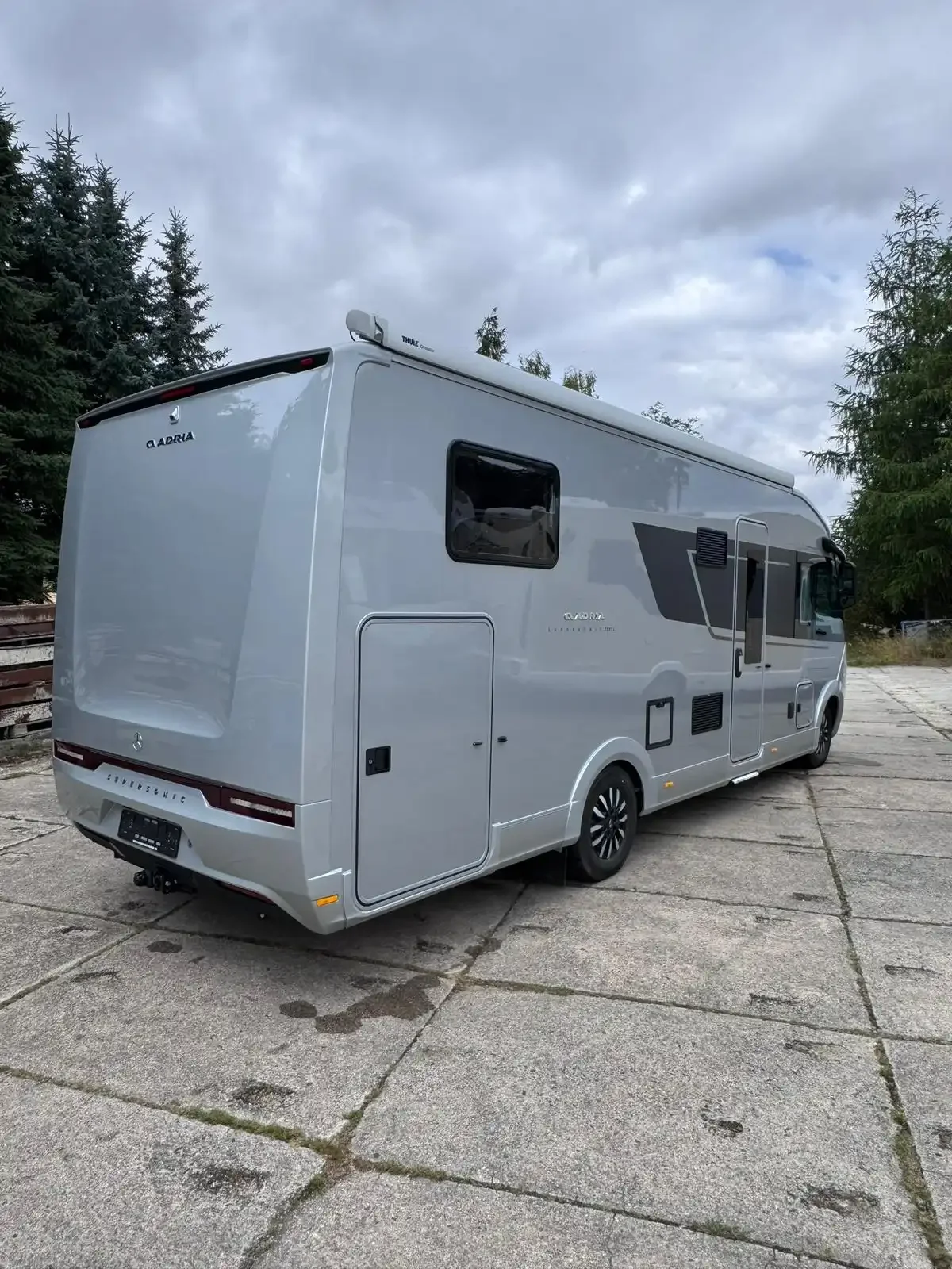 Weißes Wohnmobil mit Alkoven, schräg von hinten fotografiert.